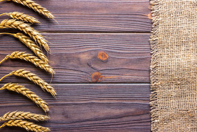 Ears of wheat and cloth on wooden background