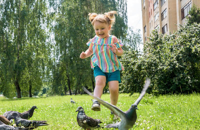 Boy playing with plants against trees