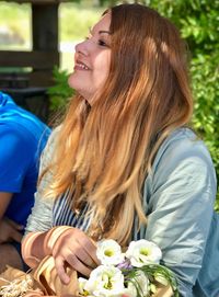 Close-up of smiling young woman with flowers