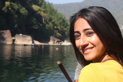 Portrait of smiling young woman in lake