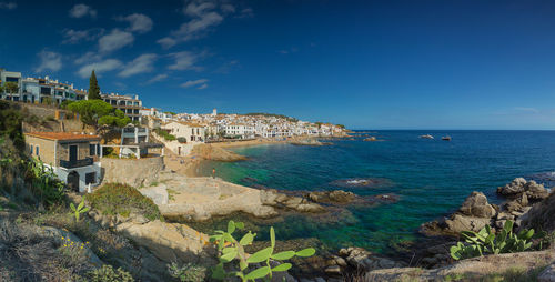 Panoramic view of sea and buildings against sky