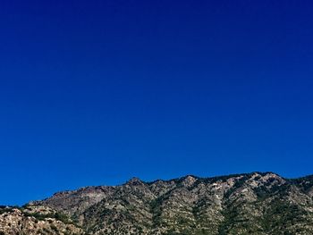 Low angle view of mountain against clear blue sky