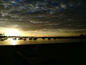 Scenic view of sea against cloudy sky at sunset