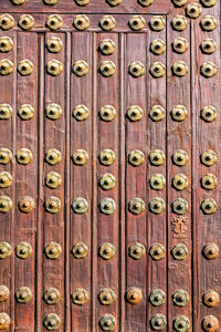 Full frame shot of metallic patterns on wooden door