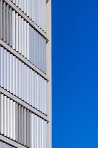 Low angle view of modern building against clear blue sky