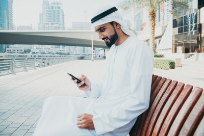 Young man using mobile phone in city