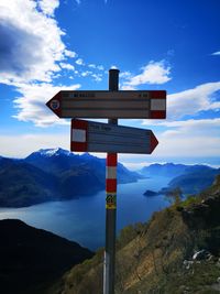 Information sign on mountain against sky