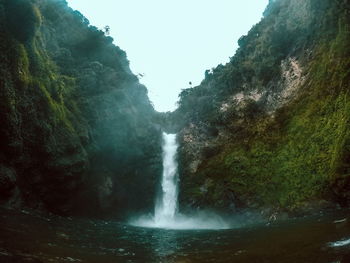 Low angle view of waterfall against sky