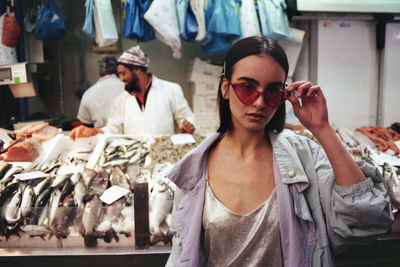 Portrait of woman wearing sunglasses while standing in market