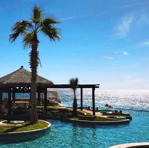 Swimming pool by sea against sky