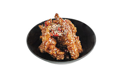 Close-up of meat in plate against white background