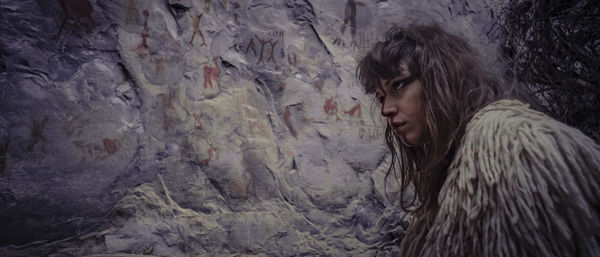 Portrait of young woman against wall