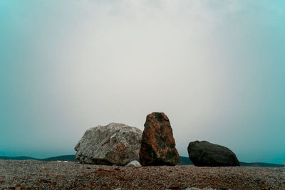 Rocks on sea shore against sky