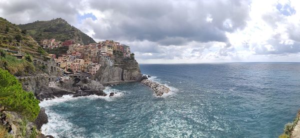 Panoramic view of sea and buildings against sky