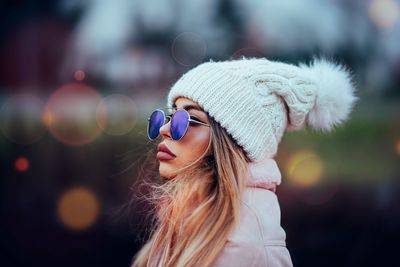 Side view of woman wearing sunglasses and knit hat