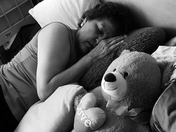 High angle view of woman sleeping with stuffed toy