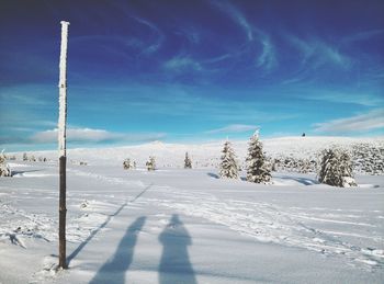 Scenic view of snow covered land against blue sky