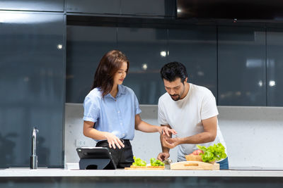 Young man and woman standing in kitchen