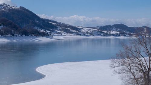 Scenic view of lake and snowcapped mountains against sky