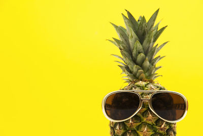 Close-up of pineapple against yellow background