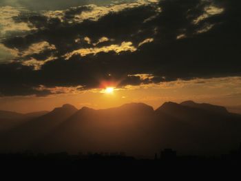 Scenic view of silhouette mountains against sky during sunset