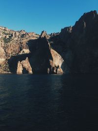 Scenic view of rocks in sea against clear sky