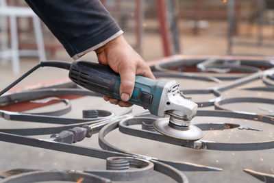 Metal grinding with angle grinder. male hand and instrument close-up