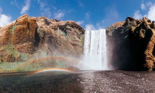 Scenic view of waterfall against sky