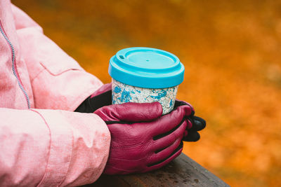 Close-up of woman holding coffee cup outdoors during winter