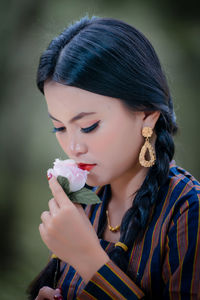 Close-up portrait of young woman blowing bubbles