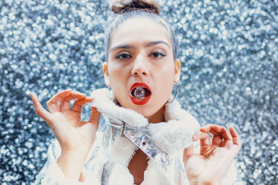 Close-up portrait of young female model with crystal in mouth