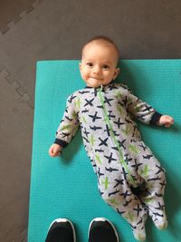 High angle portrait of cute baby boy lying on mat