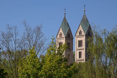 Low angle view of trees and building against sky