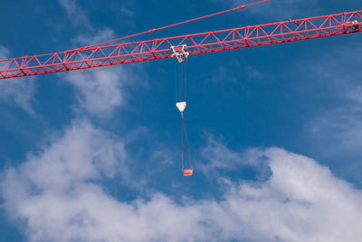 Low angle view of crane against sky