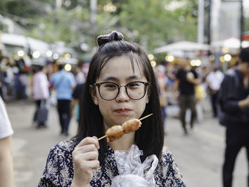 Portrait of woman eating ice cream in city