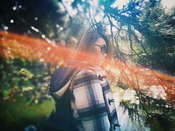 Woman standing by tree