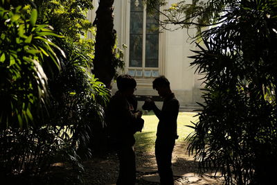 Side view of couple standing against trees
