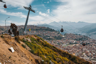 Overhead cable car over town against sky