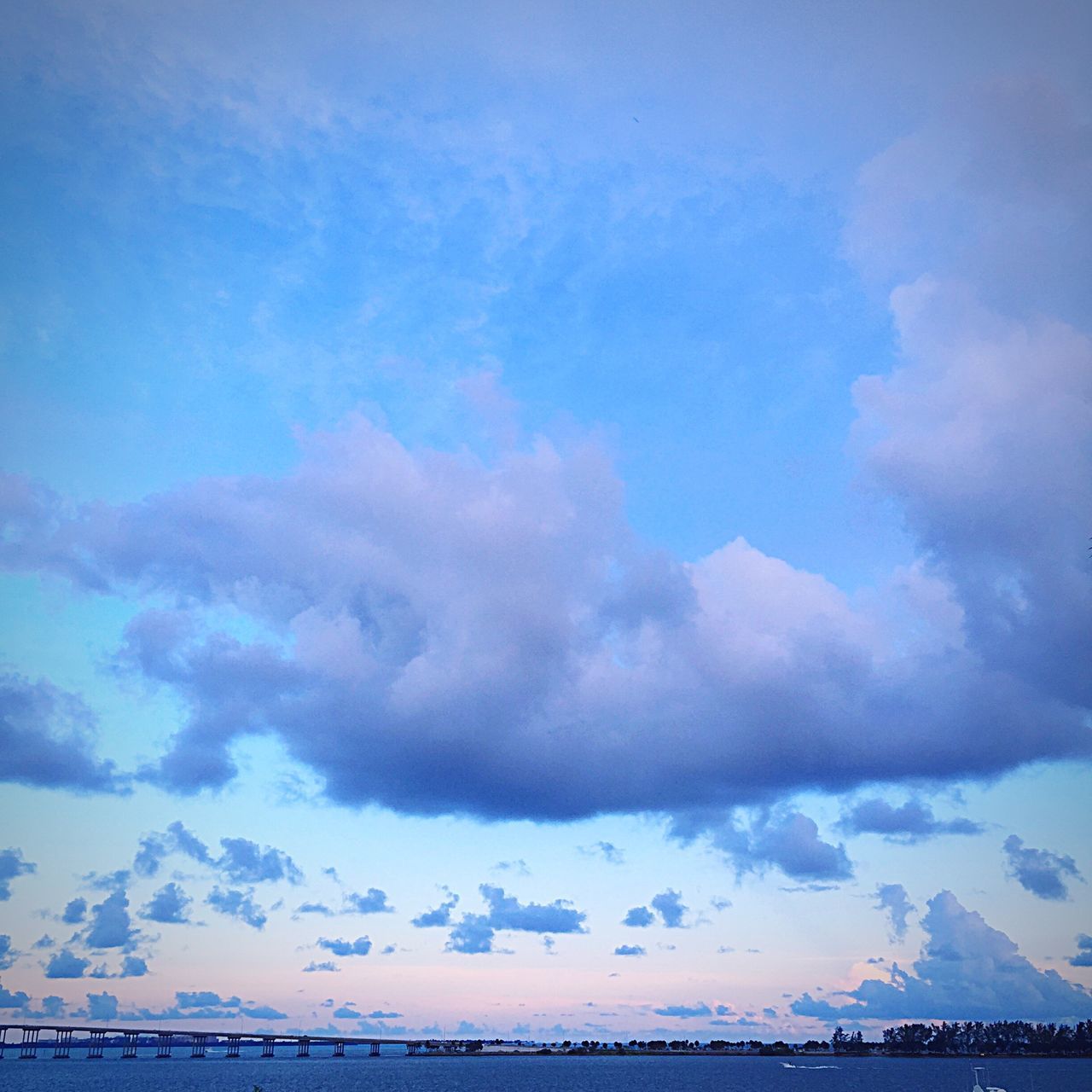 sky, scenics, tranquil scene, tranquility, beauty in nature, cloud - sky, cloudy, nature, sea, cloud, idyllic, blue, cloudscape, water, horizon over water, waterfront, weather, outdoors, no people, majestic