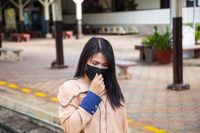 Close-up of woman wearing mask looking down on street