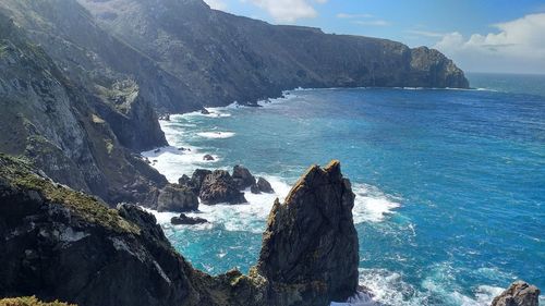 Scenic view of sea and mountains against sky