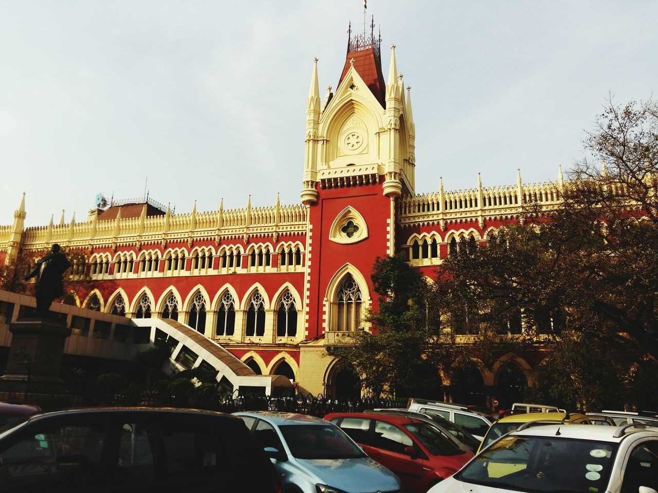 architecture, building exterior, built structure, sky, city, car, low angle view, facade, street, tree, arch, land vehicle, transportation, incidental people, travel destinations, place of worship, outdoors, building, mode of transport, religion