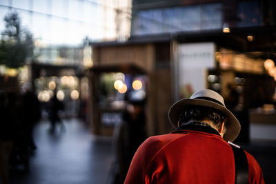 Rear view of man standing on illuminated street