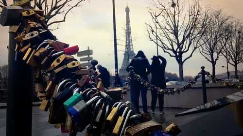 Friends standing by padlock fence in front of eiffel tower