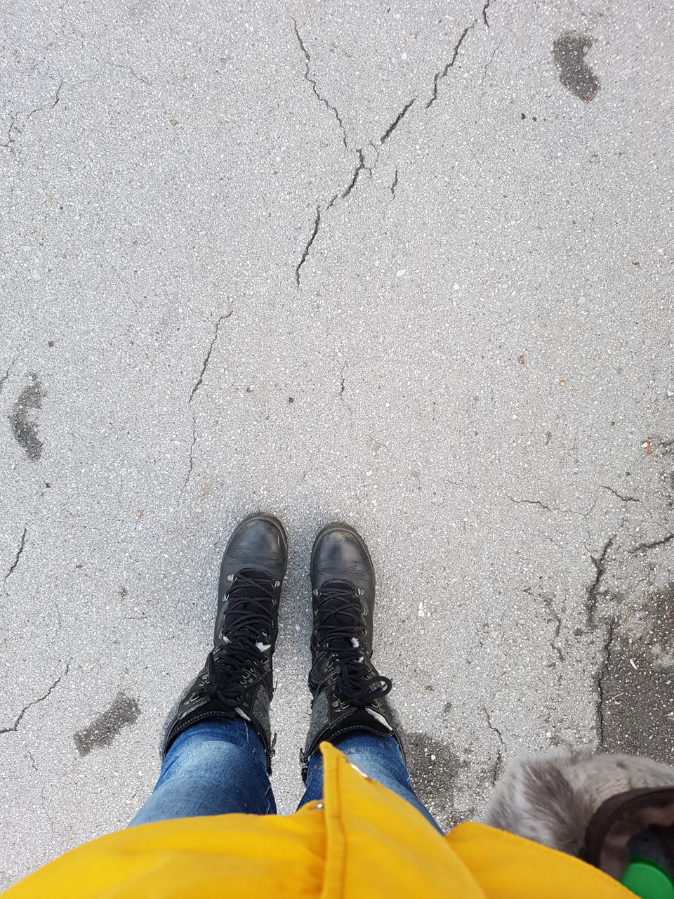 yellow, one person, low section, human leg, shoe, high angle view, lifestyles, day, footwear, asphalt, standing, leisure activity, men, outdoors, nature, limb, human limb, street, city, land, adult, road, clothing, personal perspective, casual clothing