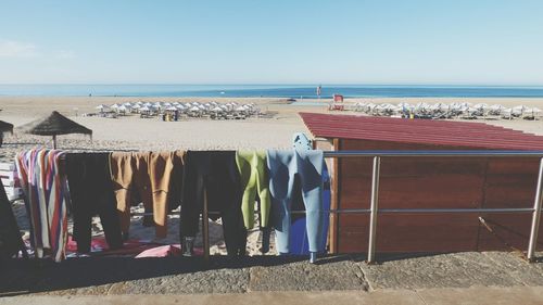 Clothes hanging on beach against clear sky