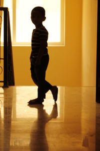 Side view of silhouette boy standing in corridor