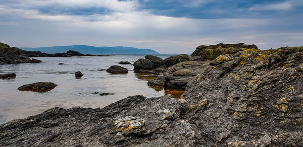 Rock formation on beach against sky