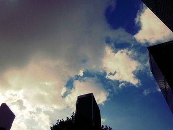 Low angle view of buildings against cloudy sky