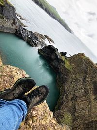 Low section of person on rock by lake